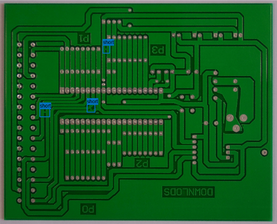 Image of a printed circuit board with three labeled bounding boxes that identify short circuit defects